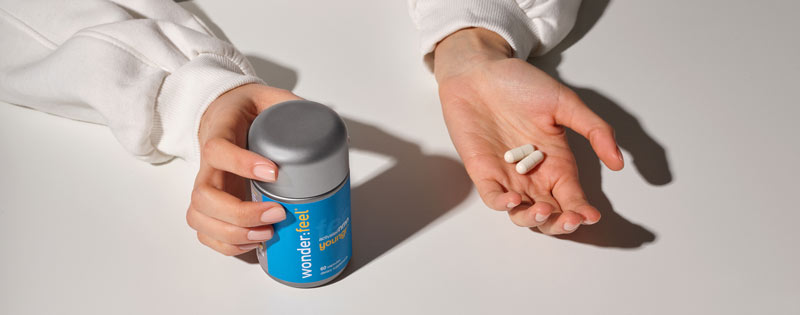 2 cápsulas en la mano para un total de 900 mg de NMN para aumentar los niveles de energía.