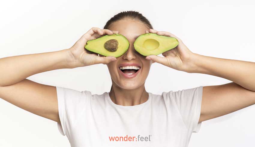 Two avocado halves over eyes representing the benefit of eating healthy fat with resveratrol.
