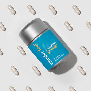 Wonderfeel Youngr NMN capsules scattered across a light gray background with the bottle placed at an angle, highlighting the multi-ingredient formulation studied for real-world benefits